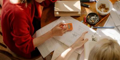 Two students engaged in studying at a table with textbooks, notes, and stationery.